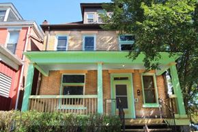 Pittsburgh apartment for rent - the front of a brick house with a green porch