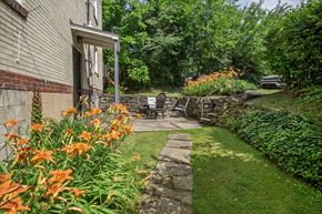 Pittsburgh apartment for rent - A garden with a stone pathway and orange flowers.