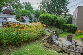 Pittsburgh apartment for rent - A garden with a bench and flowers in the foreground.