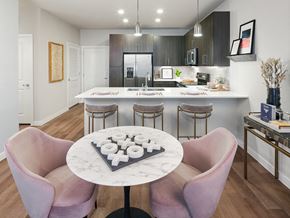 San Antonio apartment for rent - A modern kitchen with a marble table and pink chairs.