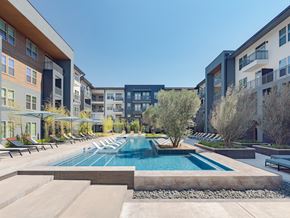San Antonio apartment for rent - A swimming pool in a courtyard surrounded by buildings.