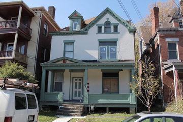 Pittsburgh apartment for rent - A white house with a green trim and a balcony.
