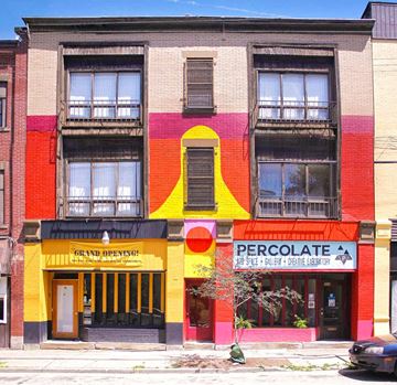 Pittsburgh apartment for rent - A building with a yellow and red facade has a sign that says "Grand Opening".