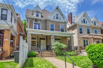 Pittsburgh apartment for rent - A house with a front porch and a white picket fence.