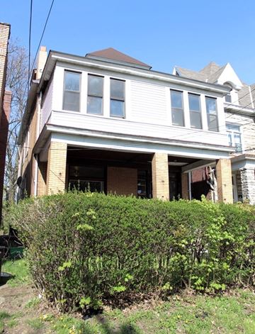 Pittsburgh apartment for rent - A house with a white garage door and a brown roof.