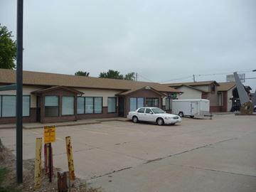 Kearney apartment for rent - a white car parked in a parking lot in front of a building