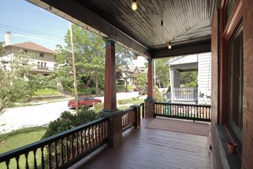 Pittsburgh apartment for rent - a view of the front porch of a house with a red car on the street