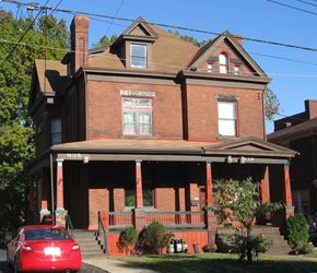 Pittsburgh apartment for rent - a red brick house with a red car parked in front of it