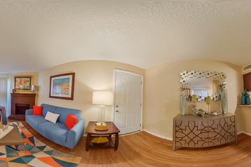 Dallas apartment for rent - A living room with a blue couch and a wooden coffee table.
