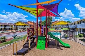 Dallas apartment for rent - A playground with a green slide and a red and yellow structure.
