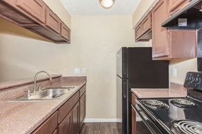 Dallas apartment for rent - A kitchen with a black stove top oven and a black refrigerator.