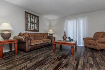 Fort Worth apartment for rent - A living room with brown leather furniture and a wooden coffee table.