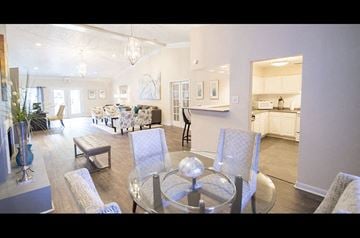 Houston apartment for rent - A modern living room with a glass table and grey chairs.