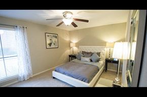 Houston apartment for rent - A bedroom with a bed, nightstand, and a ceiling fan.