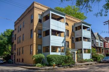 Pittsburgh apartment for rent - A building with a yellow and blue facade is situated on a street corner.