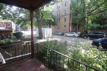 Pittsburgh apartment for rent - A view from a balcony looking out at a street with cars and buildings.