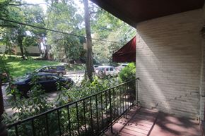 Pittsburgh apartment for rent - A balcony with a black railing overlooks a street with cars and trees.