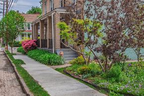 Pittsburgh apartment for rent - A brick house with a green lawn in front.