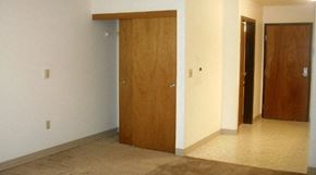 Portland apartment for rent - an empty living room with three doors in it