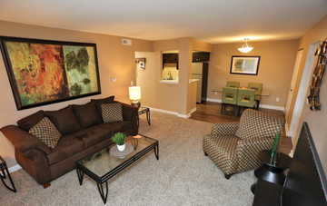 Brunswick apartment for rent - A living room with a brown couch, a glass coffee table, and a painting on the wall.