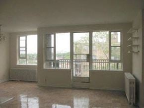 Toronto apartment for rent - an empty living room with windows and a radiator