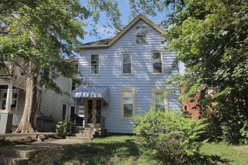 Pittsburgh apartment for rent - the front of a blue house with a porch and trees