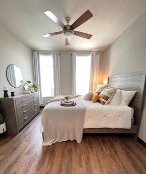 Ankeny apartment for rent - A bedroom with a bed, dresser, and ceiling fan.
