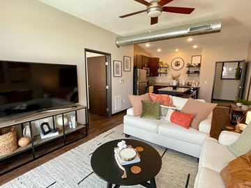 Ankeny apartment for rent - A living room with a white couch and a coffee table with a cake on it.