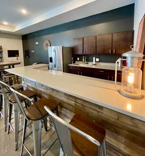 Ankeny apartment for rent - A kitchen with a white counter top and a refrigerator in the middle.