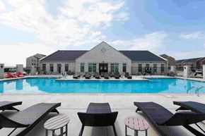 Ankeny apartment for rent - A pool with sun loungers and a building in the background.