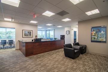 Fairfax apartment for rent - a reception area with a desk and chairs and a person sitting at the front desk