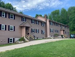 Hebron apartment for rent - a large apartment building with a driveway and a green lawn