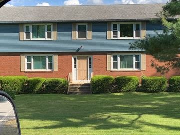 Hebron apartment for rent - a red brick house with a blue roof and a yard