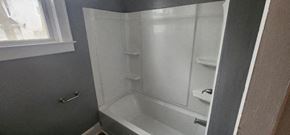 Manchester apartment for rent - a white bathroom with a white tub and a window