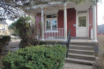 Pittsburgh house for rent - the front porch of a red house with stairs and a white door