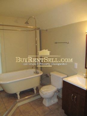 Minneapolis apartment for rent - A white toilet sits next to a white sink in a bathroom.
