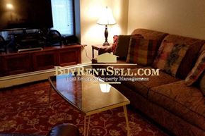 Minneapolis apartment for rent - A living room with a BuyRentSell.com sign on the coffee table.
