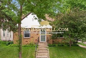 Minneapolis house for rent - an exterior view of an old brick church with a green lawn and trees