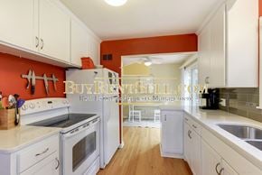 Minneapolis house for rent - a kitchen with white cabinets and stainless steel appliances