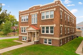 Minneapolis apartment for rent - a red brick apartment building with a green lawn and a sidewalk