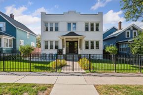 Minneapolis apartment for rent - A white two-story house with a black fence in front.