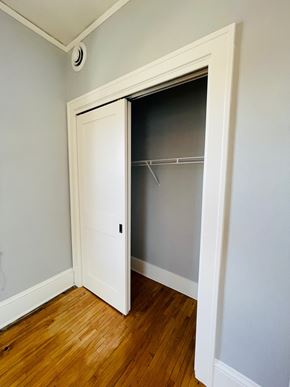 Minneapolis apartment for rent - A white door with a glass window is open in a room with wooden floors.