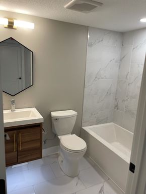 Minneapolis apartment for rent - A white toilet sits next to a white sink in a bathroom.