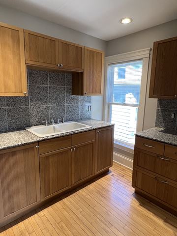 Minneapolis apartment for rent - a kitchen with wooden cabinets and a sink and a window