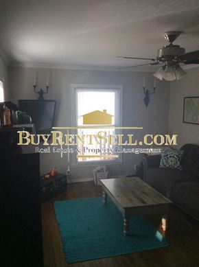 Minneapolis house for rent - A living room with a BuyRentBelow.com logo on the wall.
