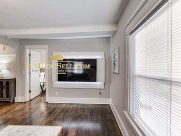 Minneapolis apartment for rent - a living room with a large window and a tv on the wall