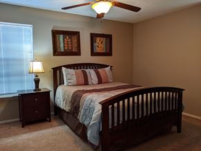 Bay City apartment for rent - A bedroom with a bed, nightstand, and two pictures on the wall.