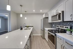 Edmonton apartment for rent - a kitchen with white cabinets and stainless steel appliances