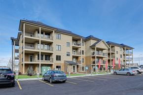 Edmonton apartment for rent - a parking lot with cars in front of an apartment building