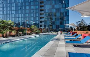 San Jose apartment for rent - Pet Friendly Apartments in Downtown San Jose, CA - One South Market Swimming Pool with Lounge Chairs, Lush Landscaping, and Table Seating
